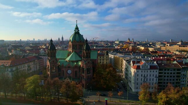 4K Aerial Drone video of beautiful autumn in city center Munich with Isar river, Saint Lukas church, Marienplatz and Maximilianeum on a sunny warm day, Germany