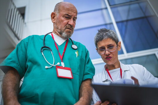 Two doctor use digital tablet on staircase outdoor - Powered by Adobe