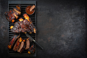 Barbecue burnt chuck beef ribs marinated with spicy rub and served as top view on a rustic cast...