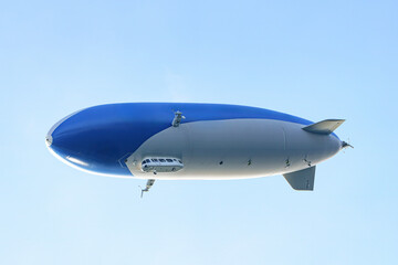 A tourist airship with passengers on board travels through the sky.