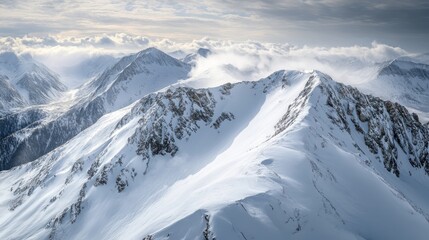 Fototapeta premium Stunning aerial view of snow-covered mountain peaks under a dramatic sky, creating a serene winter landscape.