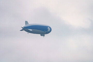 Fototapeta premium A tourist airship with passengers on board travels through the sky.
