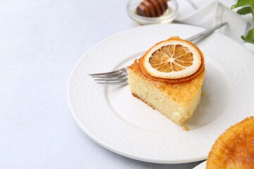 Slice of tasty semolina cake served on white table, closeup. Space for text
