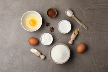 Baking powder and other products on grey textured table, flat lay