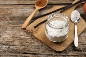Baking powder in jar on wooden table, closeup. Space for text
