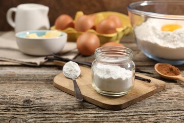Baking powder in jar and other products on wooden table