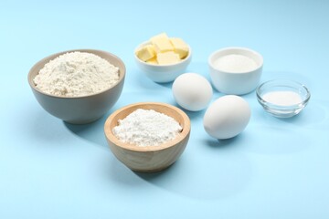 Baking powder and other ingredients for making dough on light blue background