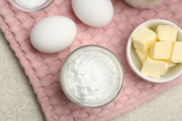 Baking powder and other ingredients for making dough on table, top view