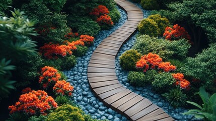 Obraz premium A winding wooden pathway through a lush garden with colorful flowers and grey stones.