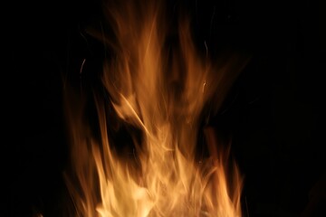 Bright golden orange flames against black background with copy space