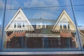 Fototapeta premium reflection of historic houses across the street of the Art Gallery of Ontario (317 Dundas Street West) on the glass and wood canopy (Galleria Italia) designed by Frank Gehry in Toronto