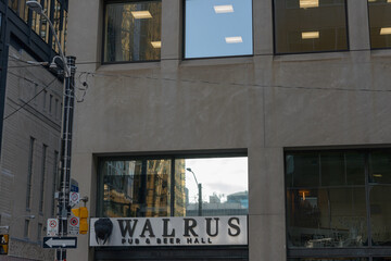 Fototapeta premium darkish facade and sign of Walrus Pub & Beer Hall, a restaurant, located at 187 Bay St in downtown Toronoto, Canada