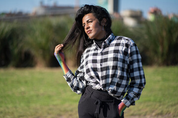 Transgender woman posing sensually in the park