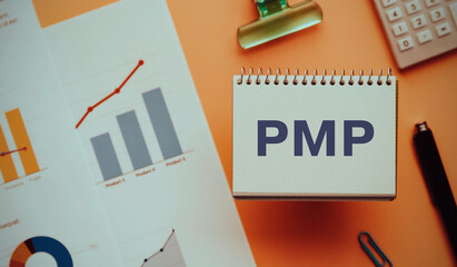 There is notebook with the word PMP. It is an abbreviation for Project Management Professional as...