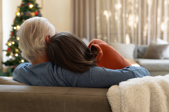 Senior couple relaxing on sofa, enjoying cozy Christmas at home together