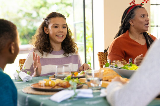 Multiracial family enjoying festive holiday meal together, at home