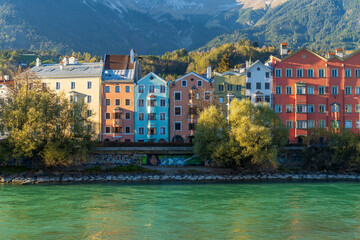Innsbruck, Austria - 04 Nov 2024: The iconic row of colorful houses along the Inn River at sunset, bathed in a golden glow. The river&rsquo;s striking green hue adds to the beauty of this picturesque scene.