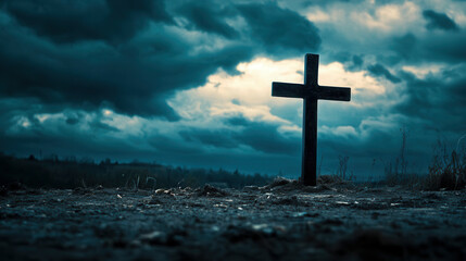 A solitary cross stands against a dramatic sky filled with dark clouds at dusk in a remote outdoor setting
