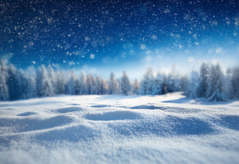 A snowy landscape with a forest in the background and falling snow against a bright blue sky.