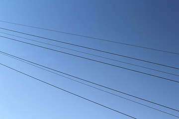 Several power electricity lines with a clear blue sky background