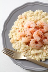 Delicious risotto with shrimps and cheese on white table, top view