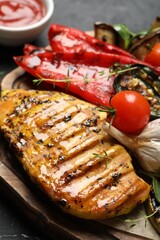 Delicious grilled vegetables and chicken breast on table, closeup