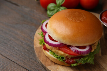 Delicious vegan burger with chickpea cutlet on wooden table, closeup