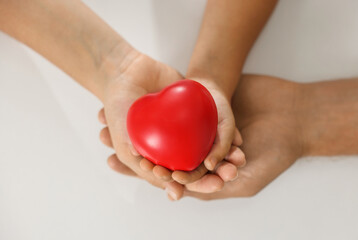 Little girl and her father with red heart figure on white background, top view