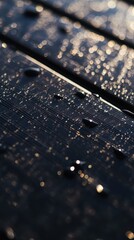 Fototapeta premium Water droplets reflecting sunlight on dark wooden surface