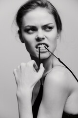 Confident young woman biting her glasses string, showcasing a bold expression and strong attitude....