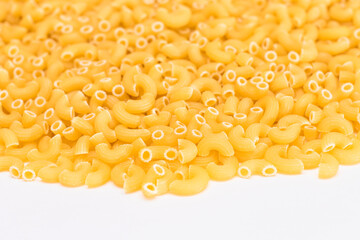 A Heap of Uncooked Chifferi Rigati Pasta on White Background. Fat and Unhealthy Food. Classic Dry Macaroni Texture. Italian Culture and Cuisine. Raw Pasta