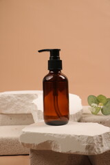 Brown Glass Skincare Pump Bottle with Eucalyptus on Earthy Background