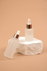 Frosted Glass Dropper Bottles with Natural Stone Aesthetic on Neutral Beige Background
