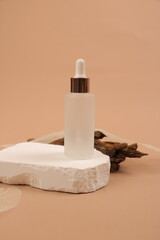 Frosted Glass Dropper Bottles with Copper Accents and Greenery on Beige Background