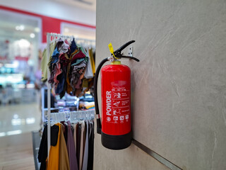 Selectively focus on a fire extinguisher hanging on the wall of a department store or mall	