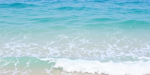 Obraz premium Blue turquoise ocean water with foamy waves crashing on the shore, marine, summer