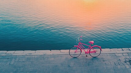 Fototapeta premium Pink Bicycle by Calm Water at Sunset