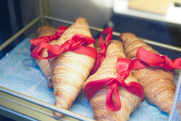 Beautiful and Elegant Croissants Beautifully Tied with Bright Red Ribbons in a Display Case