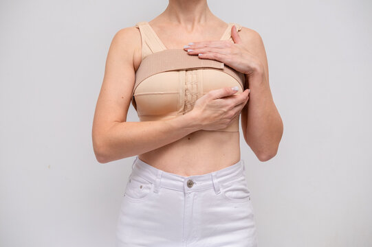 woman patient In post surgical Compression bra, implants stabilizer bra after plastic surgery medical mammoplasty, mastopexy breast enlargement, on white background