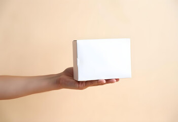 Obraz premium person holding plain white box against neutral background, conveying simplicity and minimalism. image captures sense of anticipation and curiosity