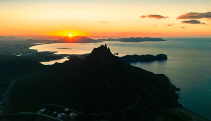 Spectacular aerial shot of the sunrise. The sun rises over the horizon illuminating the calm bay of...