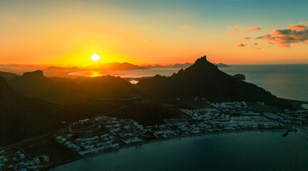 Spectacular aerial shot of the sunrise. The sun rises over the horizon illuminating the calm bay of...