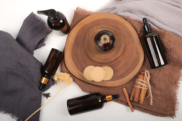 Amber Glass Skincare Bottles and Pump Dispensers on Wooden Tray with Candles
