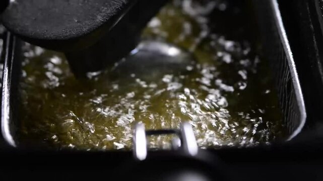 Golden panzerotto deep-frying in bubbling oil, close-up view, showing crispy texture and rich, savory Italian street food appeal.