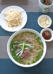 Vietnam traditional pho, Beef noodles. Pho Bo Soup with beef, rice noodles, ginger, lime, chili pepper in bowl. Vietnamese cuisine. Pho Noodle Soup