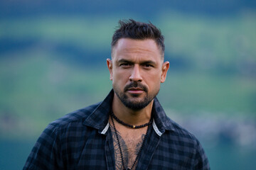 Portrait of the serious handsome man. A Hipster guy model headshot. Male serious face. Handsome serious man. Confident serious male model. Man looking proud. Closeup face of man outdoor. Elegant guy.