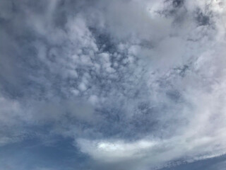 Clear sky and fluffy clouds above a rural farm field