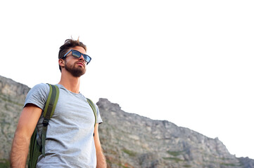 Hiking, outdoor and man with shades, travel and adventure in nature, space and tourist on cliff and serious. Mountain, thinking and person on vacation, traveller and wellness in environment and peace