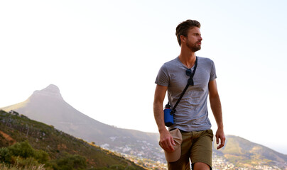 Hiking, outdoor and man on holiday, travel and adventure in nature, space and tourist on cliff and serious. Mountain, thinking and person on vacation, traveller and wellness in environment and peace