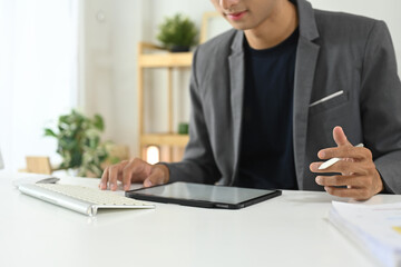 Fototapeta premium Young businessman using digital tablet at modern office